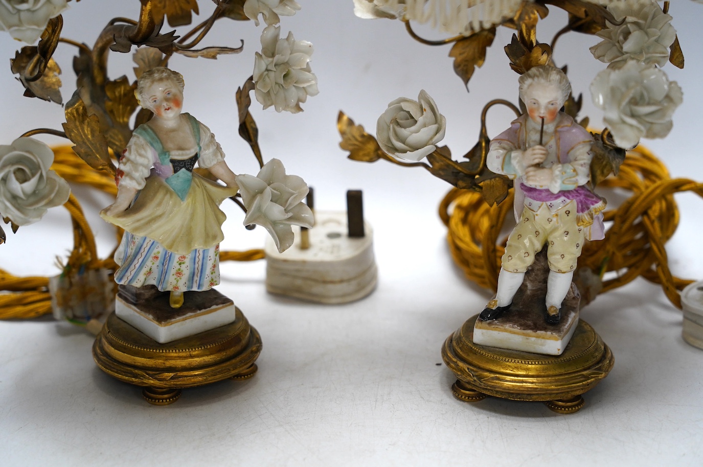 A pair of German figural porcelain and ormolu mounted table lamps with shades, overall 32cm high. Condition - fair to good, minor losses